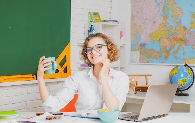 Profesor atractivo moderno Retrato de profesor joven inteligente en gafas con libro en clase en la escuela Concepto de estudio