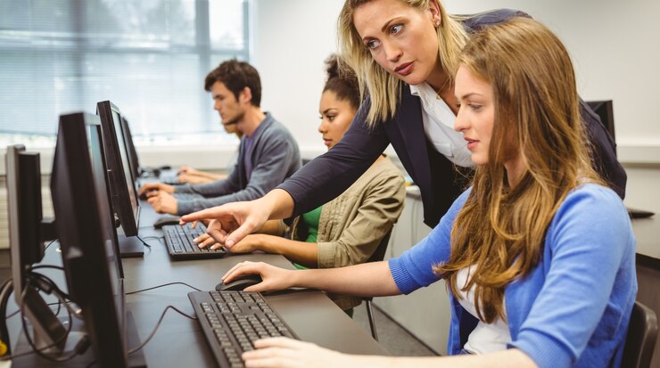 Foto profesor atractivo que ayuda a su estudiante en clase de informática
