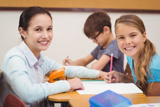 Profesor ayudando a una niña pequeña durante la clase