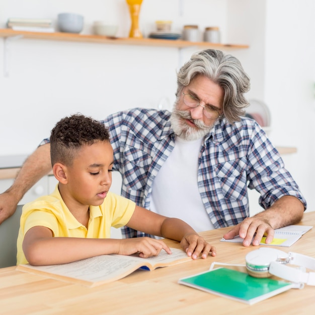 Foto profesor ayudando a niño a estudiar