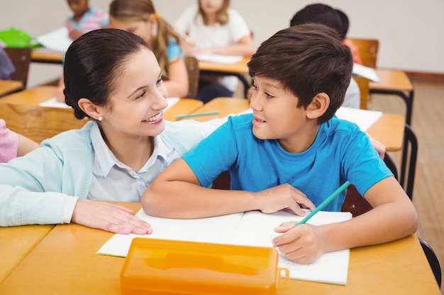 Profesor ayudando a un niño pequeño durante la clase