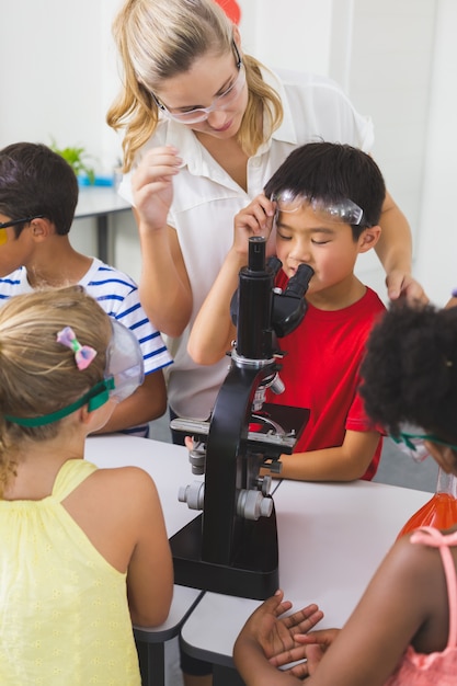 Profesor ayudando a niños en laboratorio