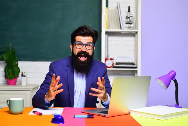 Profesor barbudo en examen de aula en estudiante universitario universitario que va a la universidad de regreso a la escuela masculino