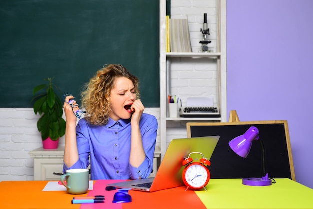 Profesor cansado que trabaja con la computadora portátil en el aula, trabajo duro, trabajo escolar, tarea, educación, concepto, mundo