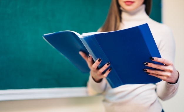 Un profesor con una carpeta en el aula.