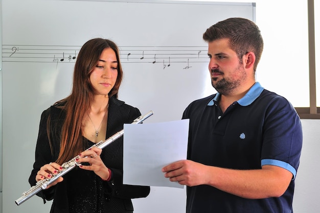 Profesor corrige música en el aula, a un joven estudiante