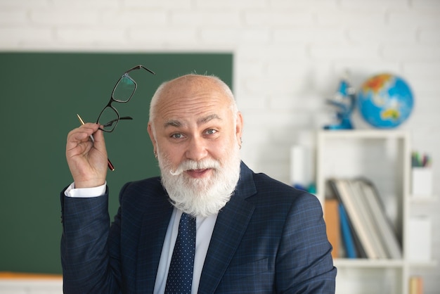 Profesor divertido en la escuela Profesor sonriendo en el aula