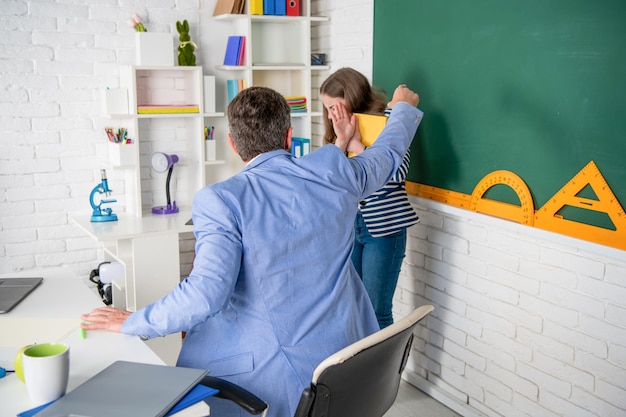 Foto profesor enojado gritando al niño en la pizarra