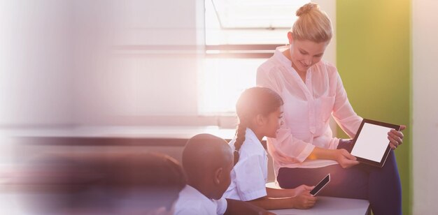 Profesor enseñando a los niños en tableta digital