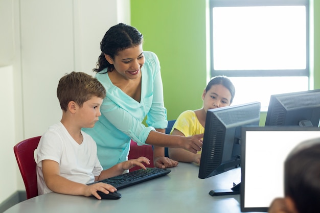 Foto profesor de enseñanza de informática a niños