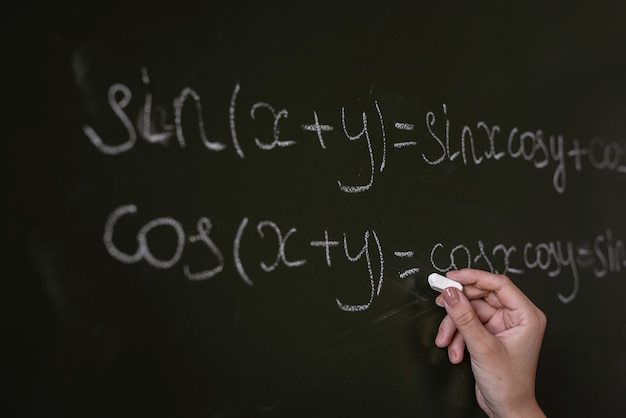 Foto profesor escrito en las fórmulas matemáticas de la junta escolar. álgebra