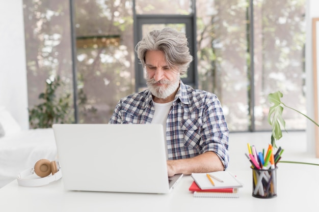 Profesor en el escritorio usando laptop