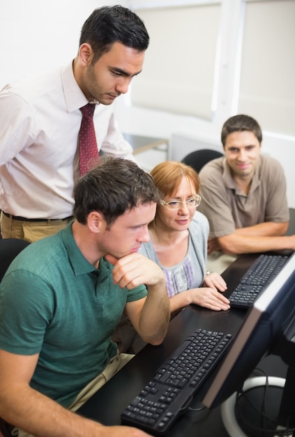 Profesor y estudiantes maduros en sala de informática