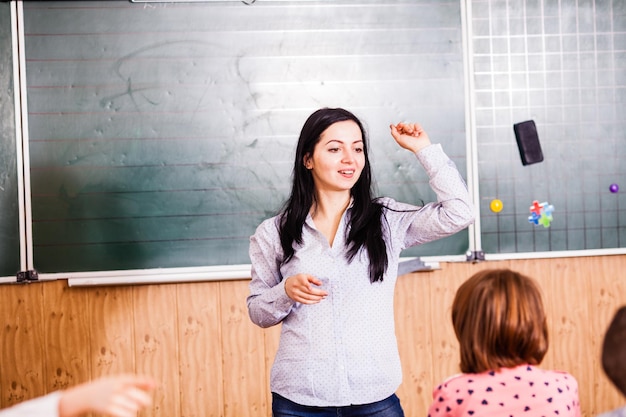 Foto el profesor explica el nuevo material de la lección para los alumnos y los alumnos adorables escuchan a su profesor.