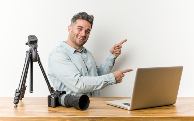 Profesor de fotografía guapo joven excitado apuntando con los dedos lejos.