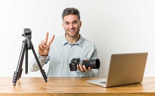 Profesor de fotografía guapo joven mostrando el número dos con los dedos.