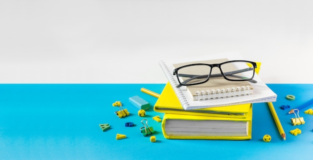 Profesor gafas, libros y letras de madera sobre una mesa azul. Concepto de día escolar y maestro. Copia espacio