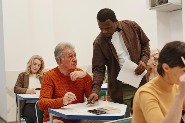 Profesor haciendo examen para estudiantes adultos.