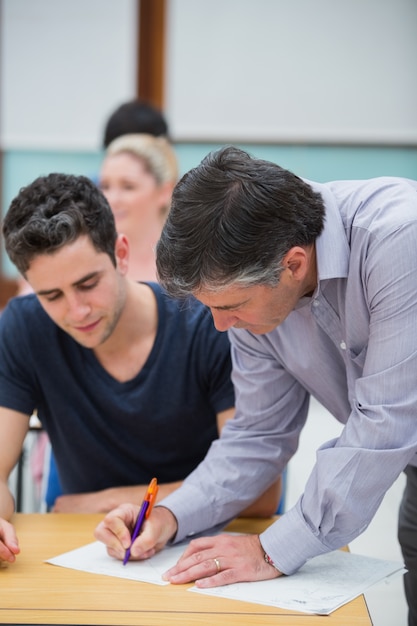 Foto profesor haciendo nota sobre el trabajo de los estudiantes