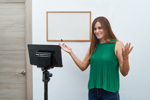 Foto profesor joven que da clases en línea en casa por videollamada. concepto de nuevas tecnologías, estudio y clases en línea.