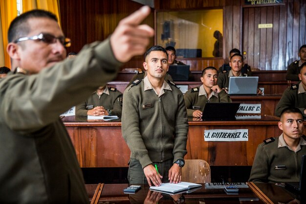 Profesor militar en clase con estudiantes atentos.