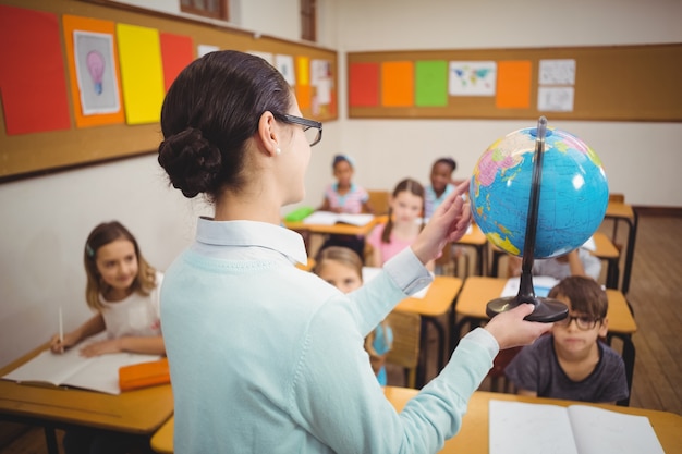 Profesor mostrando a los alumnos un globo