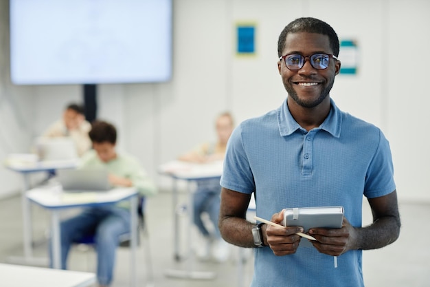 Profesor negro sonriente en el aula de la escuela