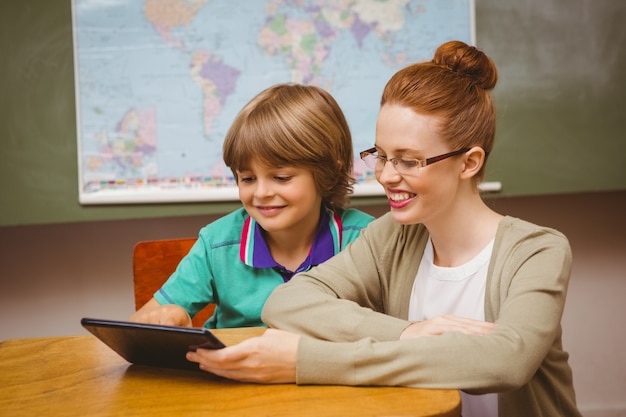 Profesor y niño usando tableta digital en el aula
