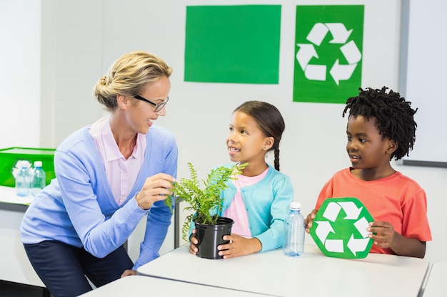 Profesor y niños discutiendo sobre reciclaje