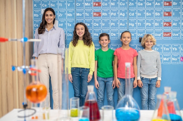 Profesor con niños de pie sonriendo a la cámara