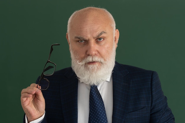 Profesor o maestro serio maestro anciano en una pizarra en blanco durante la clase de enseñanza de lecciones