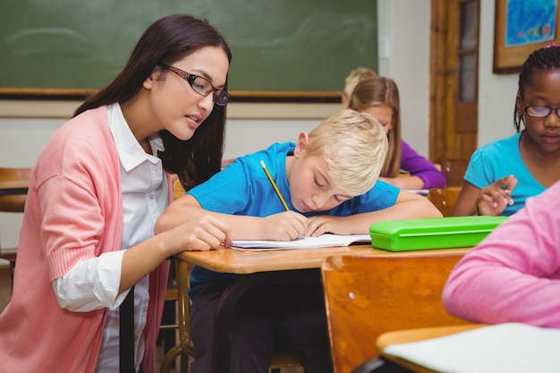 Profesor sonriente ayudando a un estudiante