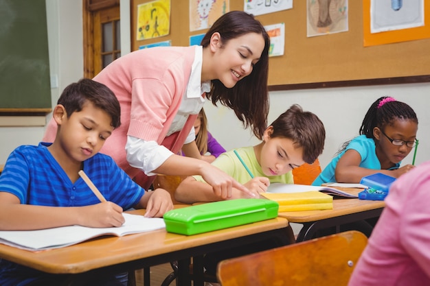 Profesor sonriente ayudando a un estudiante