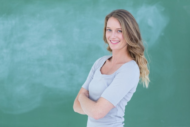 Profesor sonriente de pie delante de la pizarra