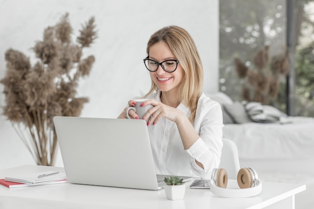 Foto profesor sonriente sosteniendo una taza de café