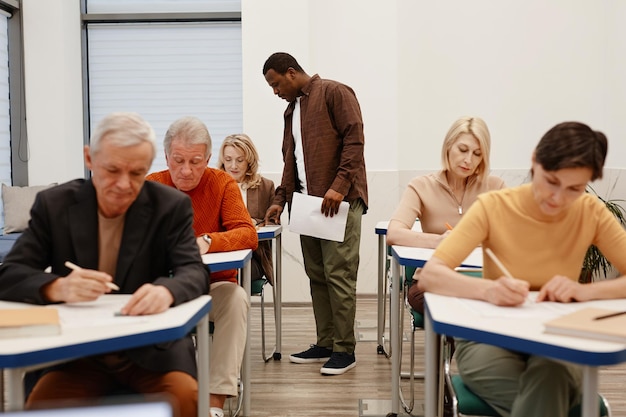 Profesor trabajando con estudiantes mayores en clase