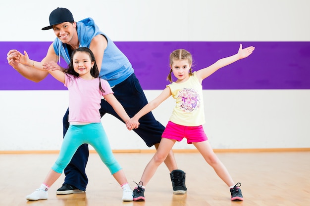 Foto profesora de baile dando clases de baile de zumba a los niños.