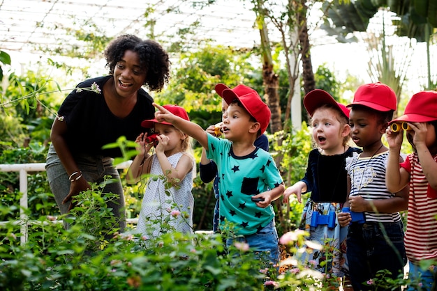 Profesores y niños escolares aprendiendo ecología jardinería