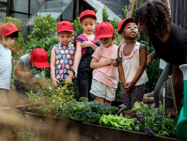 Profesores y niños escolares aprendiendo ecología jardinería