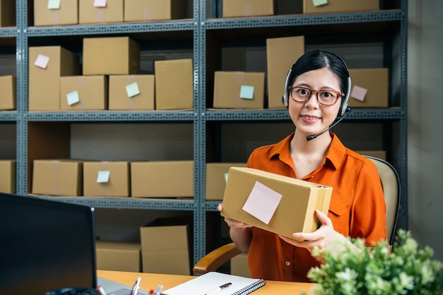 professional consult des E-Commerce-Unternehmens zeigt mit einem attraktiven Lächeln ihre perfekte Verpackung in die Kamera