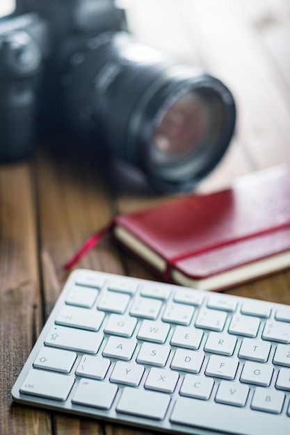 Foto professionelle digitalkamera und computer-tastatur auf einem holztisch