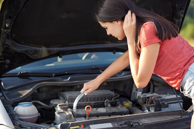 Professionelle Fahrerin versucht, Auto zu reparieren