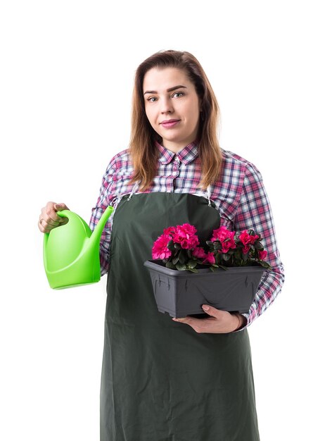 Professionelle Gärtnerin oder Floristin in Schürze mit Blumen in einem Topf und Gartengeräten isoliert auf weißem Hintergrund