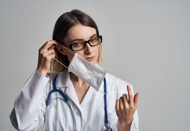 Professionelle Krankenschwester in einem medizinischen Kleid und einer Maske auf dem Gesicht eines Infektionslabors