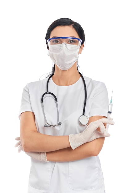 Professionelle Ärztin in Schutzmaske, Brille und Handschuhen mit Spritze