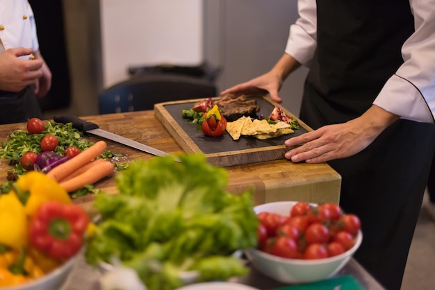 Professionelle Teamköche und Köche bereiten Mahlzeiten in der geschäftigen Hotel- oder Restaurantküche zu