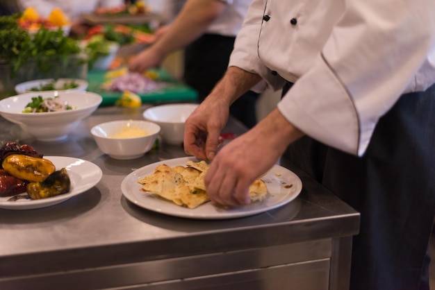 Professionelle Teamköche und Köche bereiten Mahlzeiten in der geschäftigen Hotel- oder Restaurantküche zu