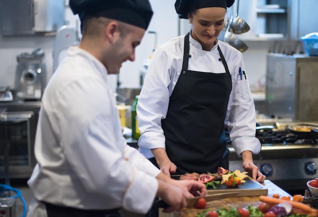 Professionelle Teamköche und Köche bereiten Mahlzeiten in der geschäftigen Hotel- oder Restaurantküche zu