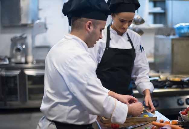 Professionelle Teamköche und Köche bereiten Mahlzeiten in der geschäftigen Hotel- oder Restaurantküche zu