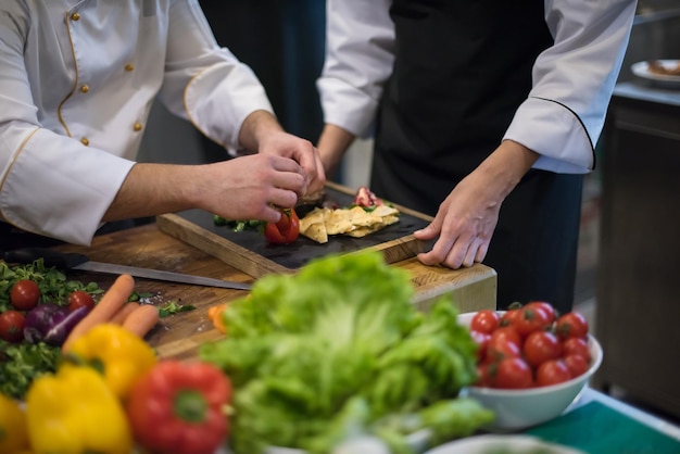 Professionelle Teamköche und Köche bereiten Mahlzeiten in der geschäftigen Hotel- oder Restaurantküche zu